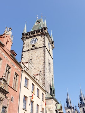 Old Town Hall Tower in Prague with clock and spires against clear sky.