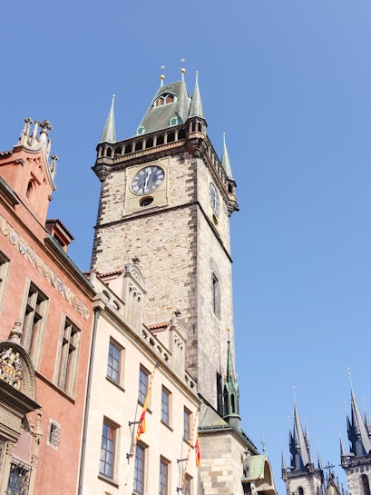 Old Town Hall Tower in Prague with clock and spires against clear sky.