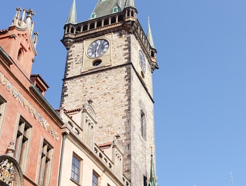 Old Town Hall Tower in Prague with clock and spires against clear sky.