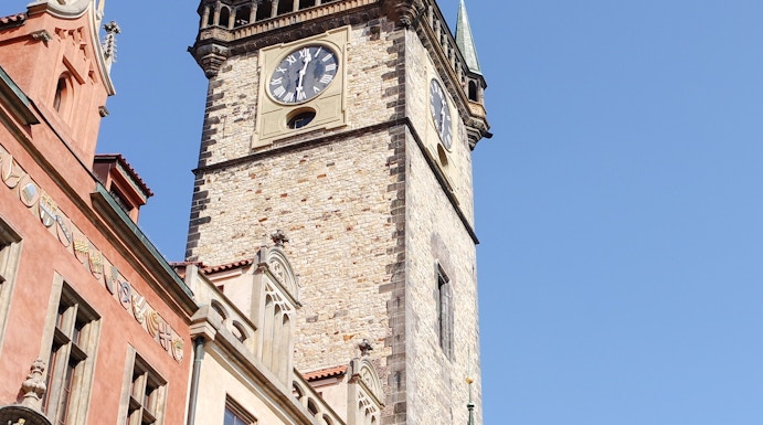Old Town Hall Tower in Prague with clock and spires against clear sky.