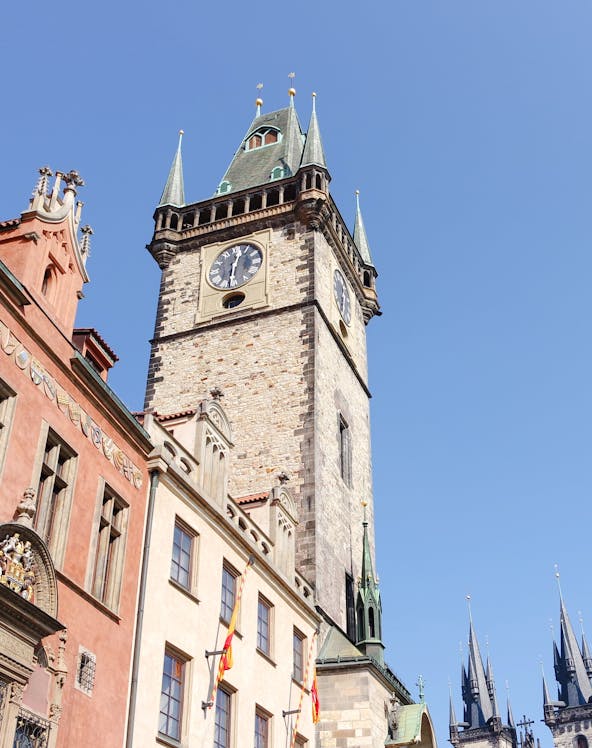 Old Town Hall Tower in Prague with clock and spires against clear sky.