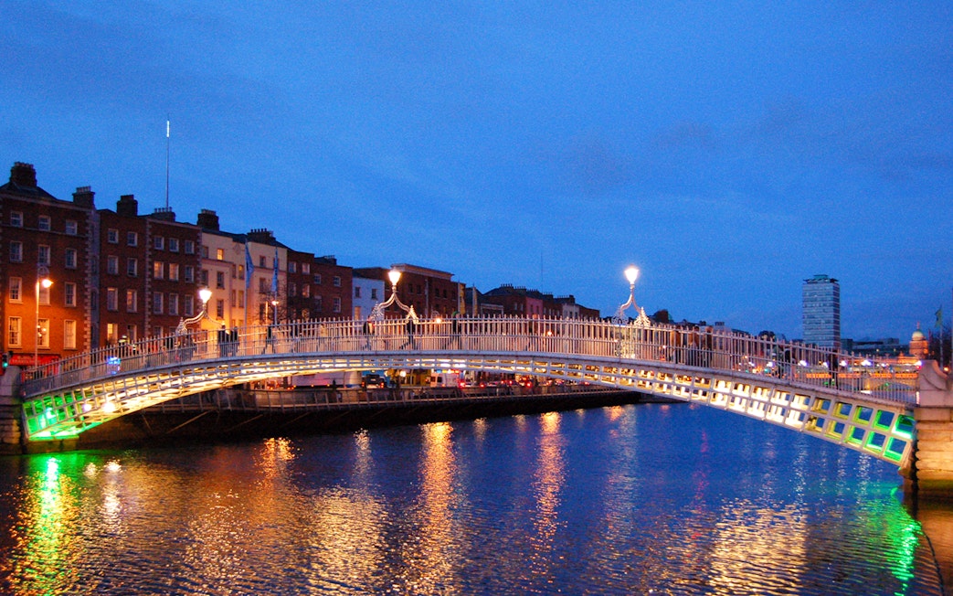 Ha'penny Bridge illuminated at night over the River Liffey in Dublin, Ireland.