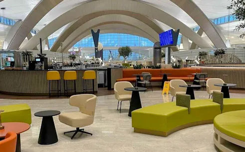 VIP lounge seating area at Abu Dhabi International Airport with modern decor and bar.