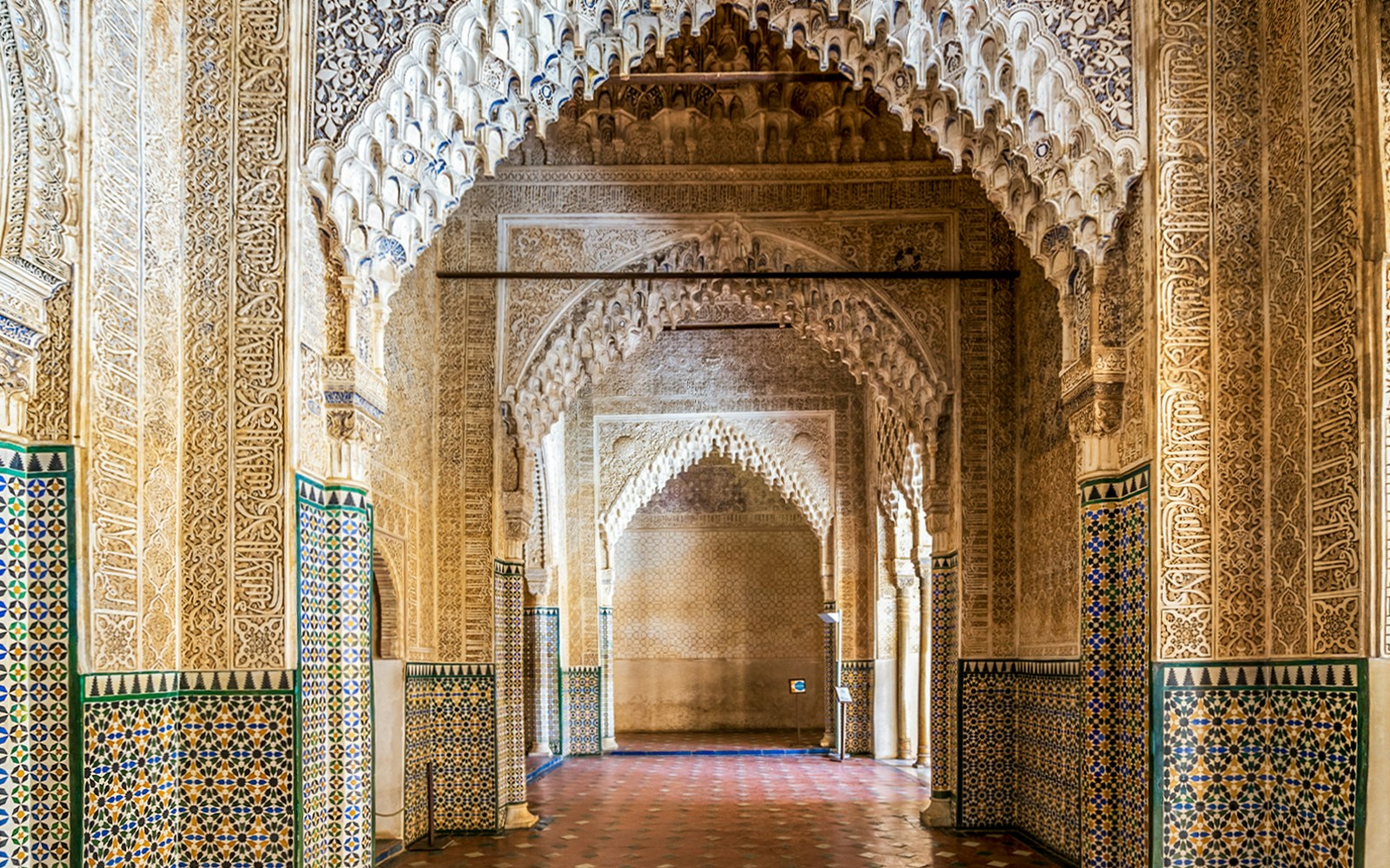 Alhambra intricate arches and tilework on guided tour in Granada, Spain.