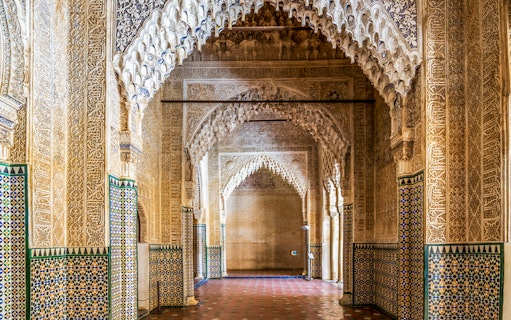 Alhambra intricate arches and tilework on guided tour in Granada, Spain.