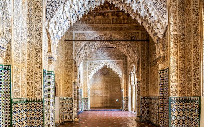 Alhambra intricate arches and tilework on guided tour in Granada, Spain.