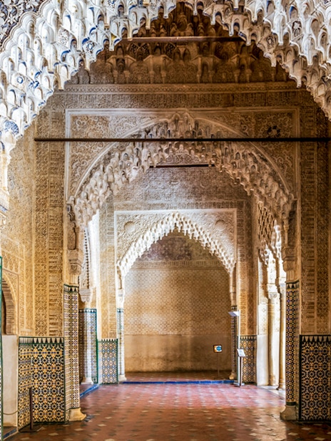 Alhambra intricate arches and tilework on guided tour in Granada, Spain.