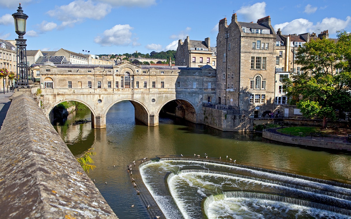 Pulteney Bridge over River Avon in Bath, featuring historic architecture and cascading weir.