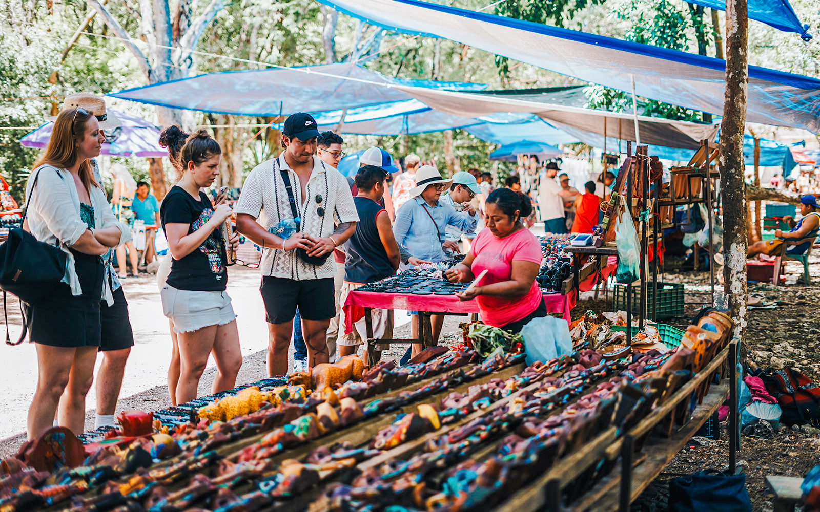 Shoppers browsing handcrafted items at a vibrant outdoor Mexican market.