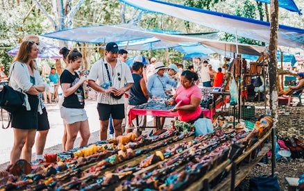Shoppers browsing handcrafted items at a vibrant outdoor Mexican market.