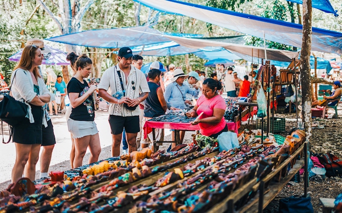 Shoppers browsing handcrafted items at a vibrant outdoor Mexican market.