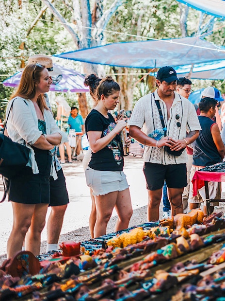 Shoppers browsing handcrafted items at a vibrant outdoor Mexican market.