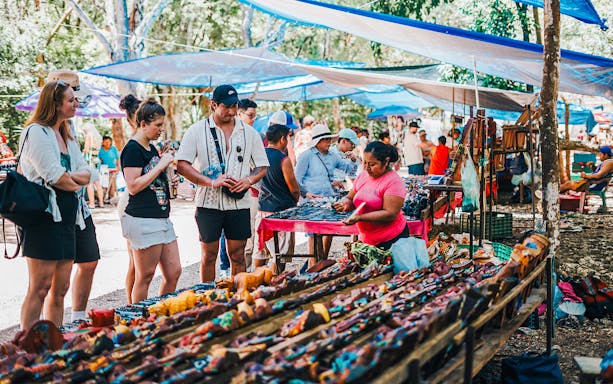Shoppers browsing handcrafted items at a vibrant outdoor Mexican market.