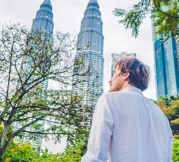 Man walking near Petronas Towers in Kuala Lumpur, Malaysia.
