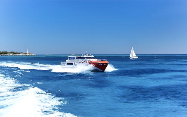 Ferry approaching Rottnest Island with lighthouse in view, part of Perth adventure tour.