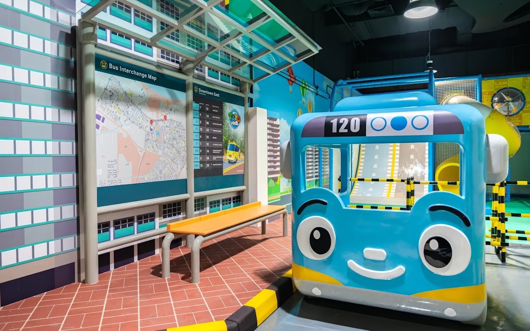 Blue bus model at Tayo Station with map and seating area.