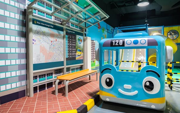 Blue bus model at Tayo Station with map and seating area.