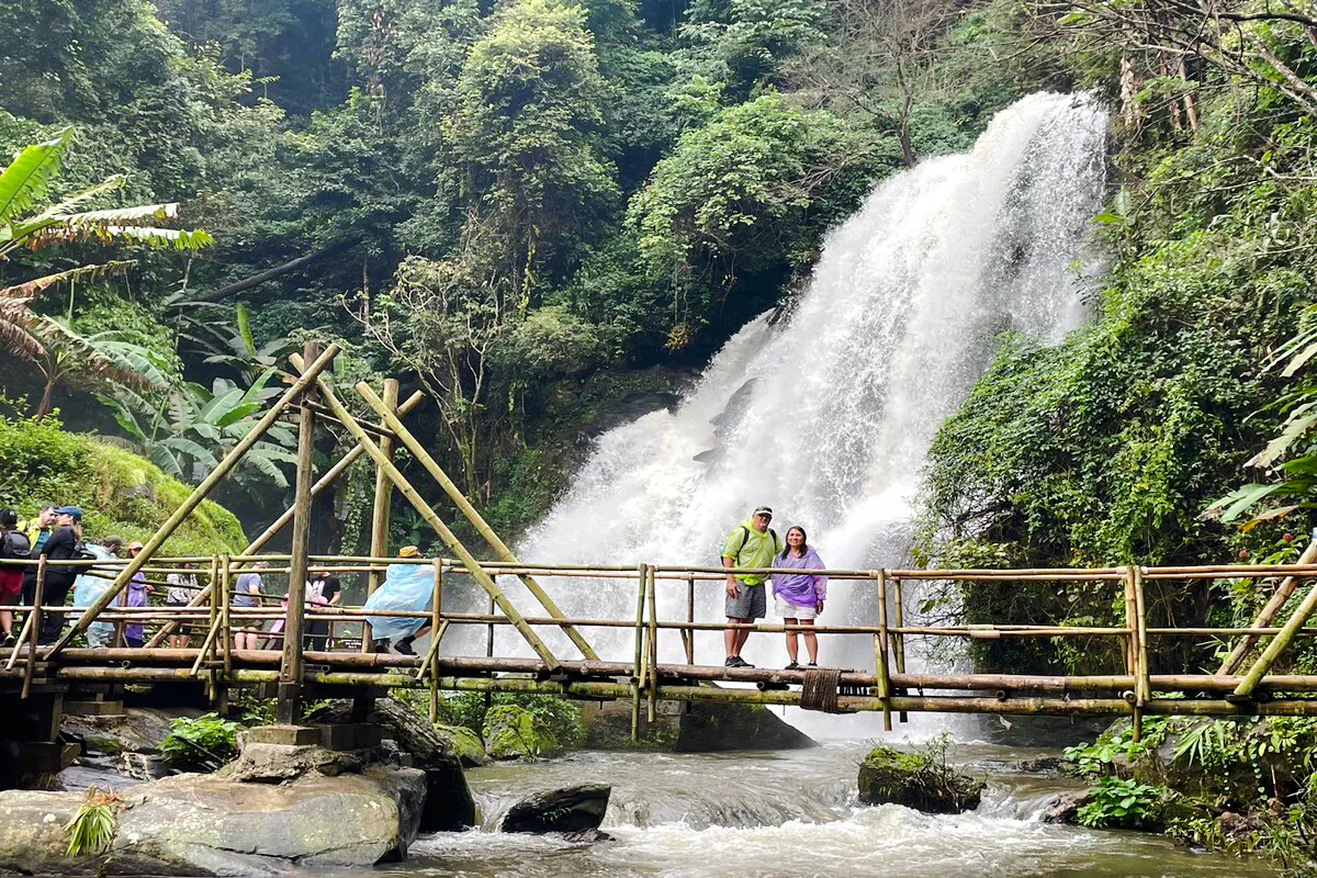 Visitors on a bamboo bridge near a waterfall in Doi Inthanon National Park, Chiang Mai.