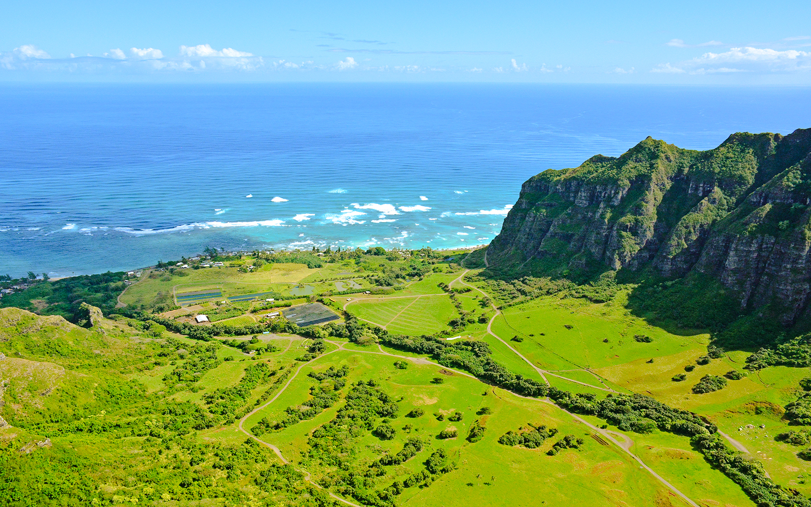 Aerial view of lush green valleys and ocean at Kualoa Ranch, east side, Hawaii.