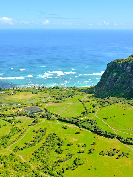 Aerial view of lush green valleys and ocean at Kualoa Ranch, east side, Hawaii.