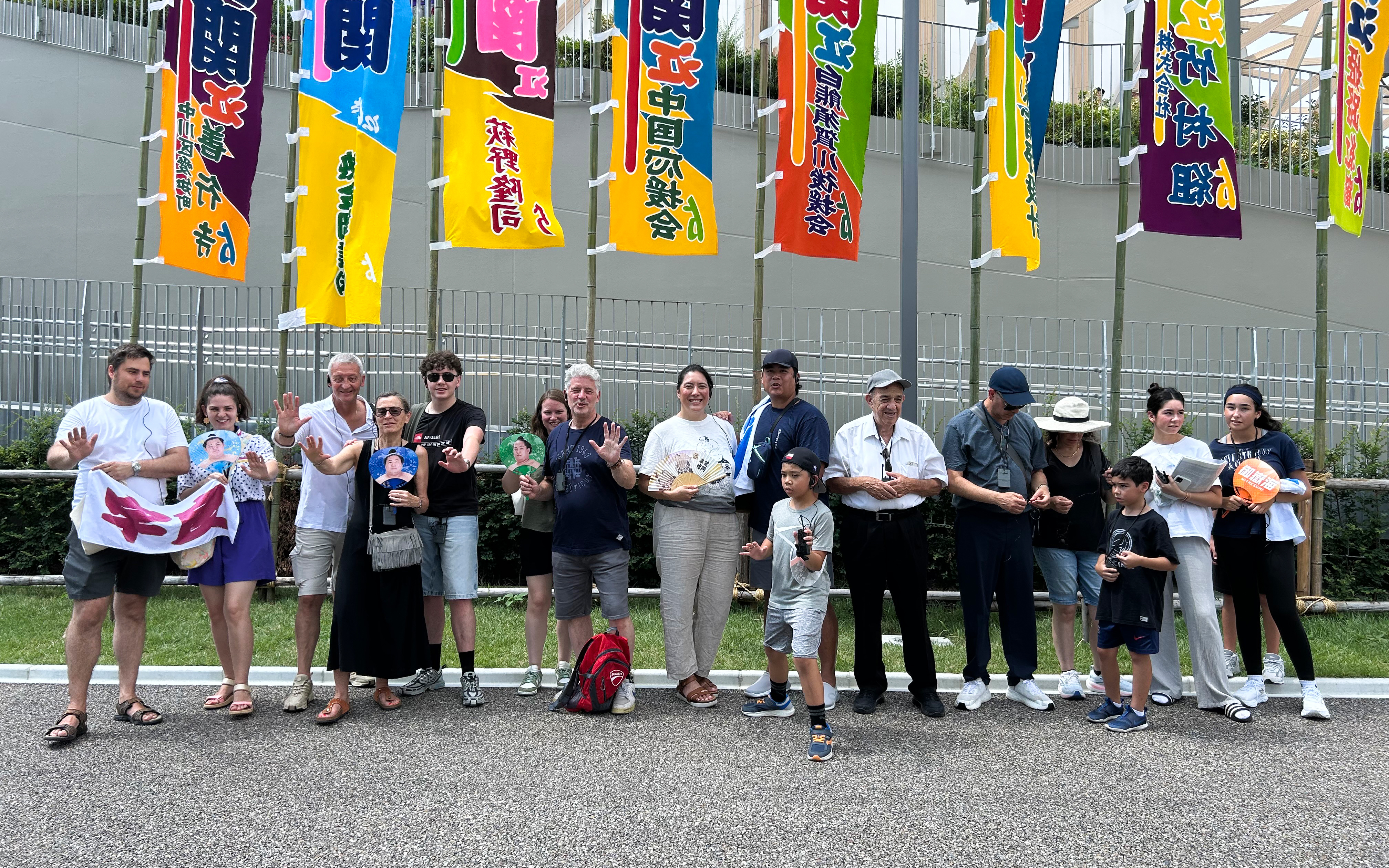 Spectators outside Nagoya Grand Sumo Tournament venue with colorful banners.