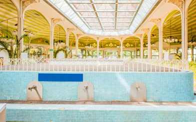Indoor pool area at Széchenyi Spa, Budapest with ornate architecture and skylight.