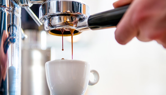 Espresso pouring into cup at Caffè Pedrocchi, Italy.