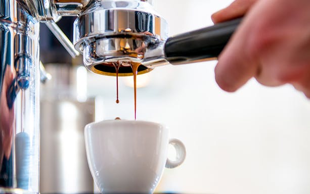 Espresso pouring into cup at Caffè Pedrocchi, Italy.