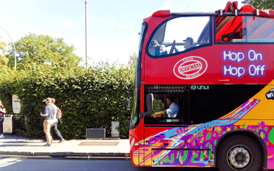 Stavanger hop-on hop-off bus with colorful design on city street.