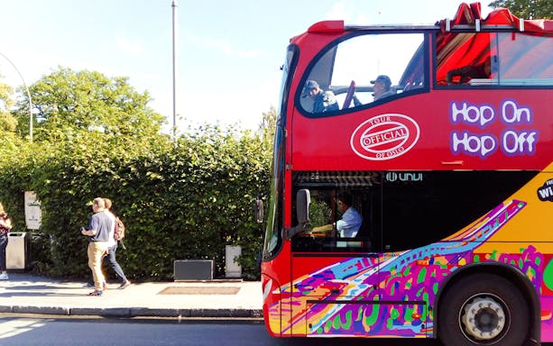 Stavanger hop-on hop-off bus with colorful design on city street.