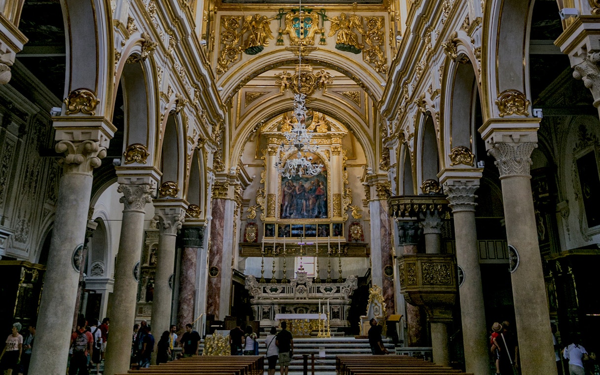 Interior of a historic church in Matera with ornate arches and altar, part of Sassi guided tour.