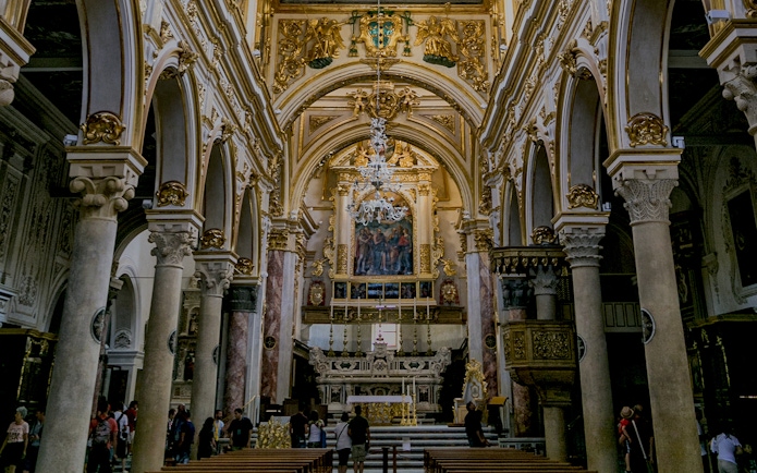 Interior of a historic church in Matera with ornate arches and altar, part of Sassi guided tour.