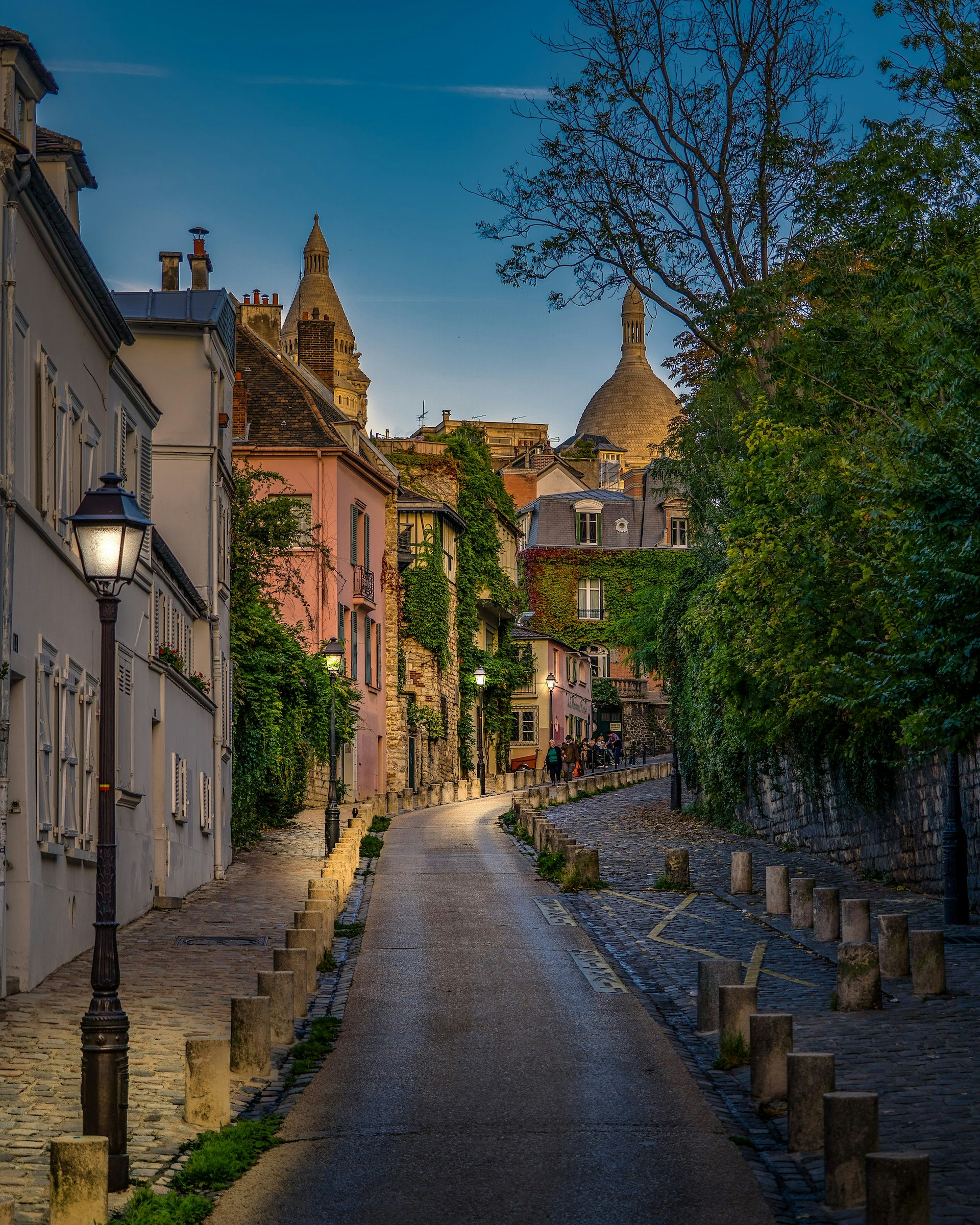 Sacre-Coeur Basilica in Montmartre, Paris, with tourists exploring the steps and surrounding area.