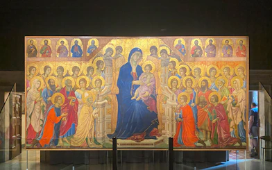 Alt text: "Tourists viewing the Maestà by Duccio at the Siena Duomo Complex in Siena, Italy.
