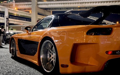 Orange sports car at Daikoku PA in Tokyo, showcasing local car culture.