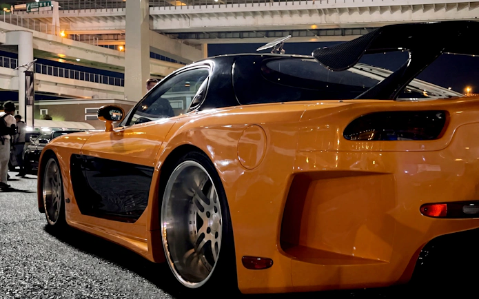 Orange sports car at Daikoku PA in Tokyo, showcasing local car culture.