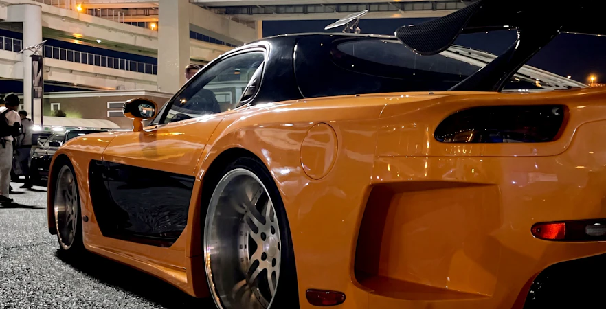 Orange sports car at Daikoku PA in Tokyo, showcasing local car culture.