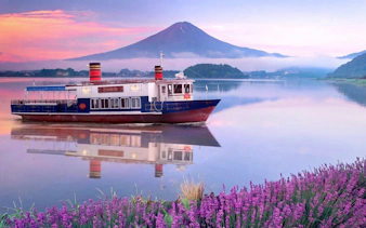 Boat on Lake Kawaguchi with Mount Fuji in background, near Oishi Park, Japan.