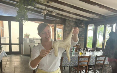 Person stretching mozzarella in Amalfi Coast farmhouse cooking class.