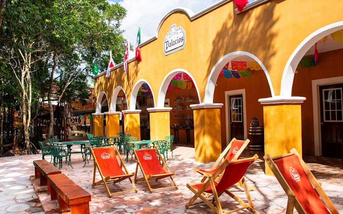 Courtyard with colorful chairs and arches in Cancun jungle setting.
