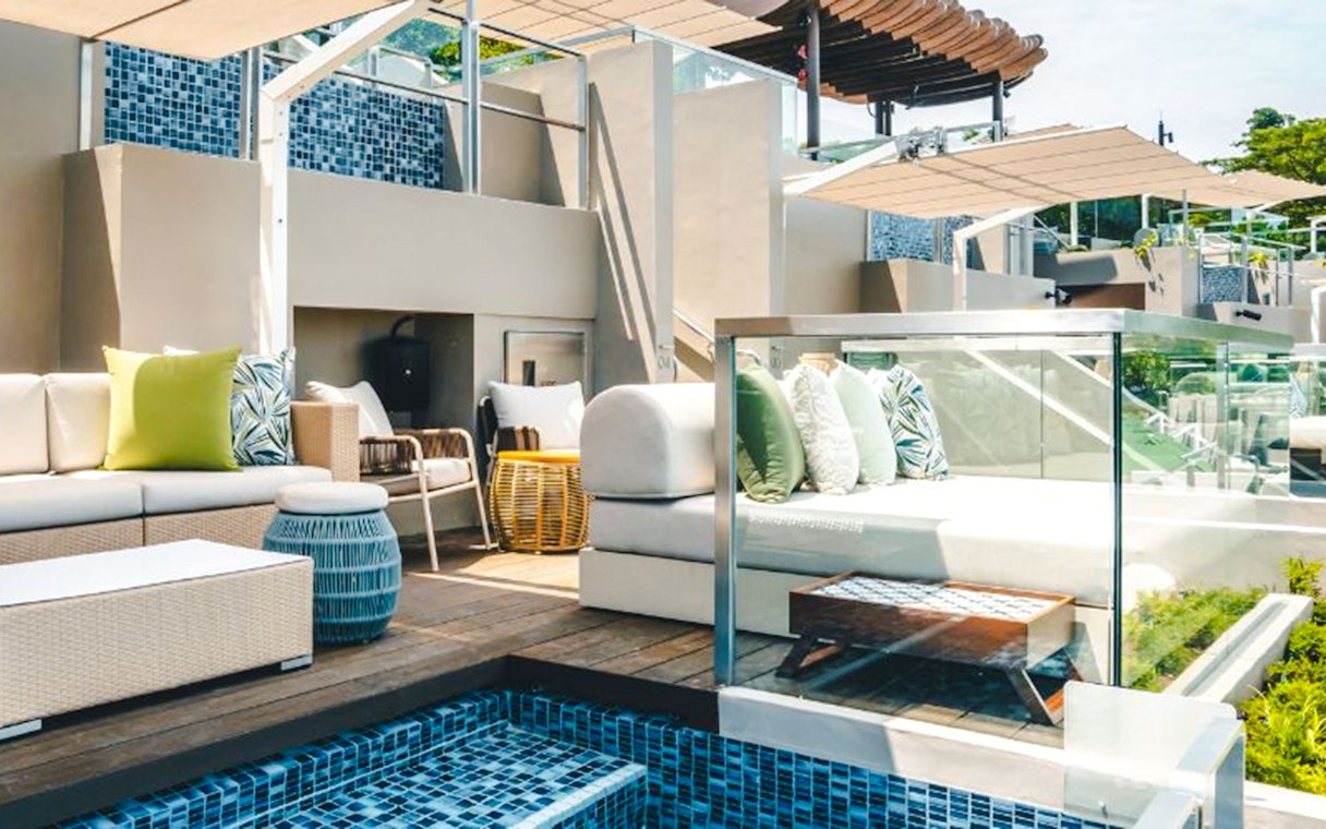 Twelve Beach Club cabana with seating area and poolside view.