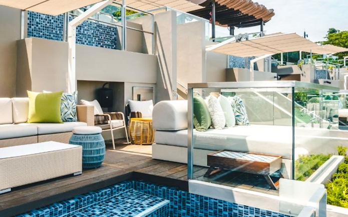 Twelve Beach Club cabana with seating area and poolside view.