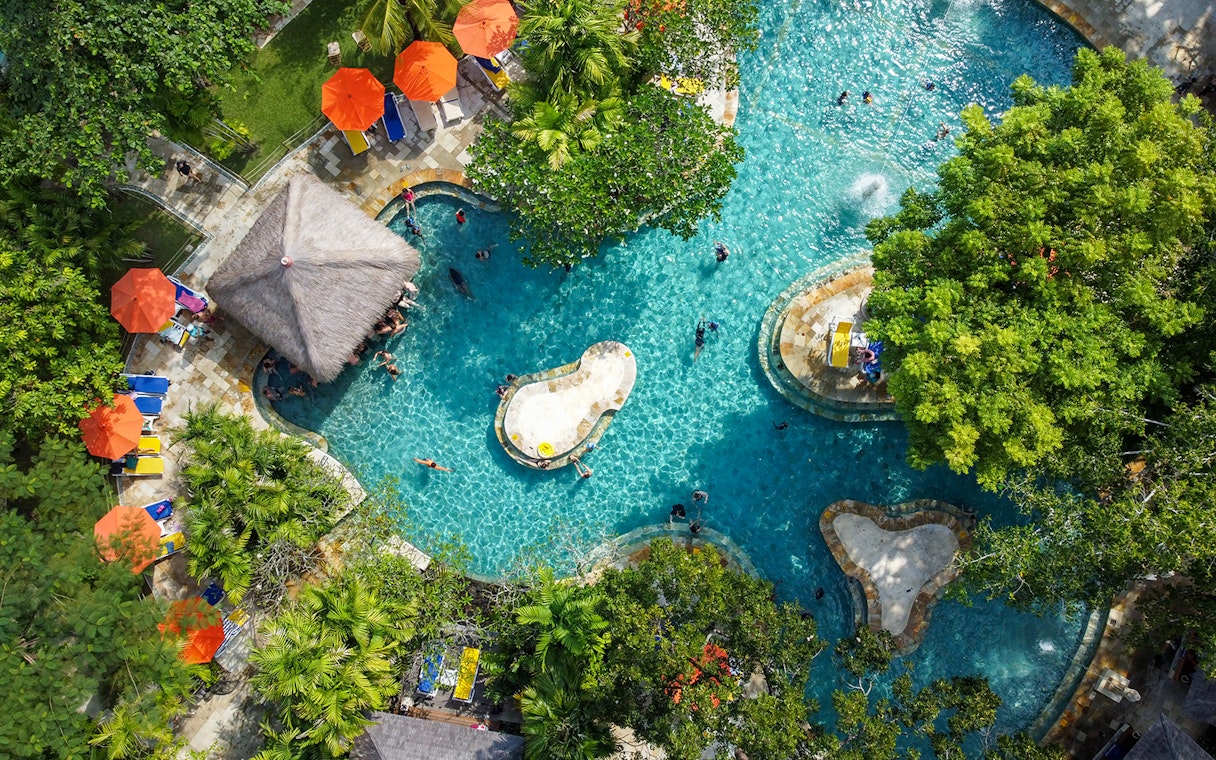 Aerial view of the Pleasure Pool at Waterbom Bali with sun loungers and umbrellas.