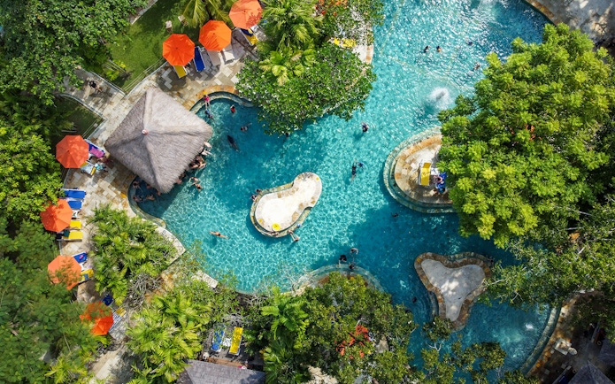 Aerial view of the Pleasure Pool at Waterbom Bali with sun loungers and umbrellas.