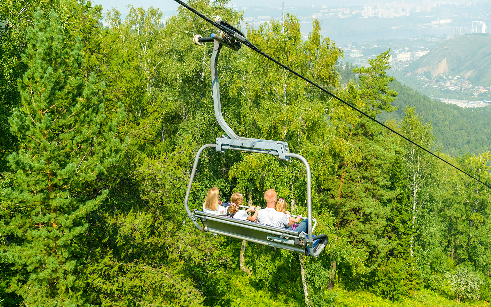 Chairlift ride at ESCAPE Penang theme park, Malaysia, offering scenic views of lush greenery.