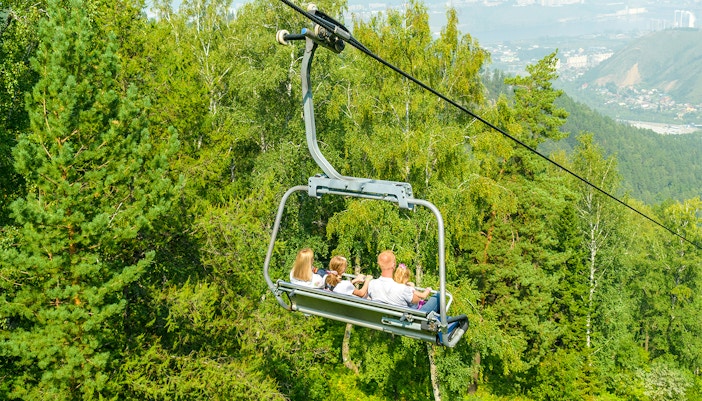 Chairlift ride at ESCAPE Penang theme park, Malaysia, offering scenic views of lush greenery.
