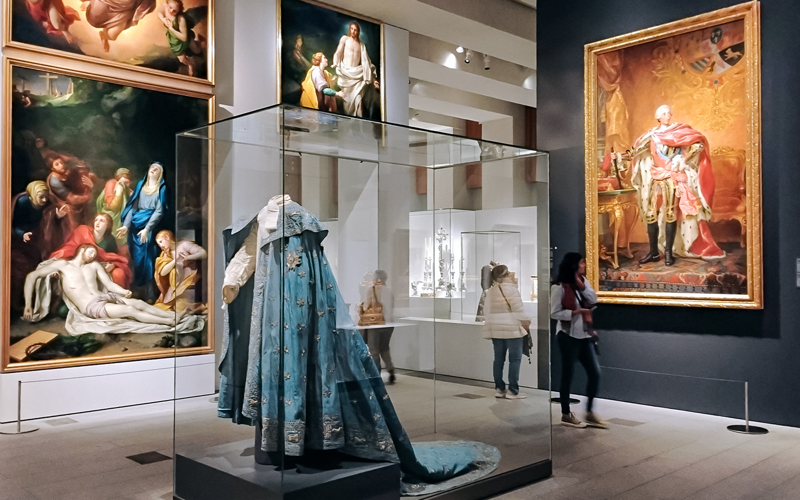 Royal Collections Gallery interior with visitors viewing art in Madrid, Spain.