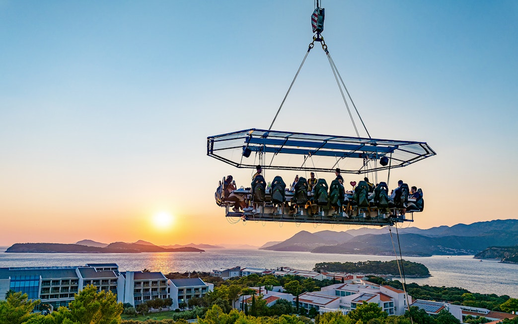 Guests dining in the sky above Dubrovnik with a sunset view of the Adriatic Sea.