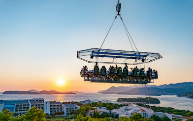 Guests dining in the sky above Dubrovnik with a sunset view of the Adriatic Sea.