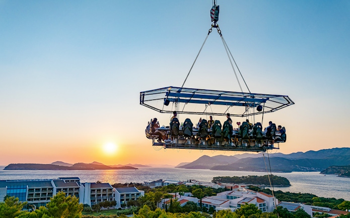 Guests dining in the sky above Dubrovnik with a sunset view of the Adriatic Sea.